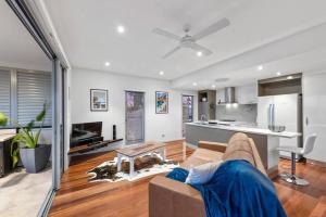 a living room with a couch and a kitchen at Penthouse - Scarborough beach break holidays in Scarborough