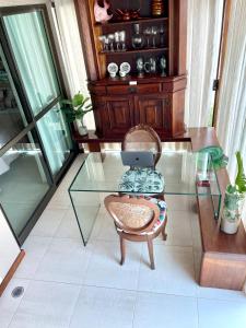 einem Glastisch mit einem Stuhl und einem Laptop darauf in der Unterkunft FLAT MURO ALTO Manihi1101 in Porto De Galinhas