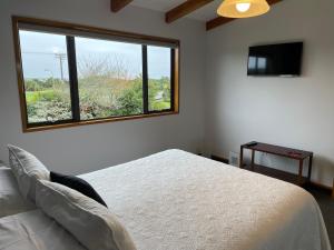 a bedroom with a bed and a large window at Amberlea B&B in Hokitika