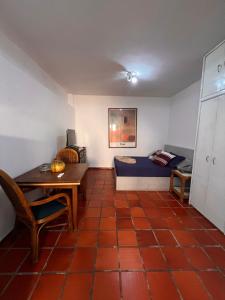 a room with a bed and a table and a desk at Un rinconcito en Pampatar in Pampatar