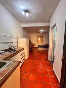 uma cozinha com piso em azulejo laranja em Un rinconcito en Pampatar em Pampatar