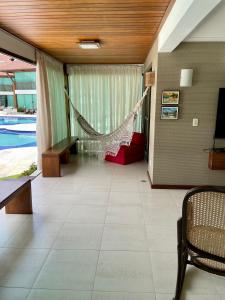 eine Hängematte in einem Wohnzimmer mit Pool in der Unterkunft FLAT MURO ALTO Manihi1101 in Porto De Galinhas + 69 Fotos