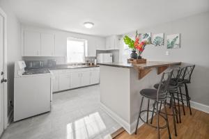 a kitchen with white cabinets and a counter with stools at Hangout by firepit near USC with PET in Columbia