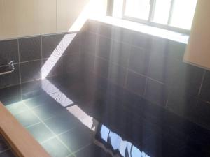 a black tiled counter in a bathroom with a window at 池の平温泉 ロッジ コクハ in Myoko