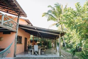 an outdoor patio with a wooden pergola at Vila Fruta Pão in Caraíva