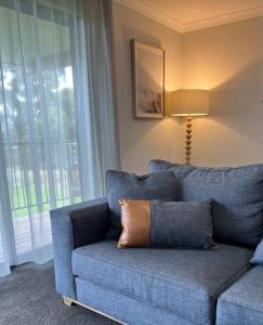 a blue couch with a pillow on it in a living room at 44onRoaring - in the Huon Valley in Surveyors Bay