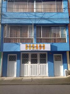 un bâtiment bleu avec un panneau devant lui dans l'établissement HOTEL BOGOTA AIRPORT DORADO, à Bogotá