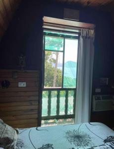 Schlafzimmer mit einem Bett und einem Fenster mit Aussicht in der Unterkunft Miramar Chalé e Suítes in Angra dos Reis