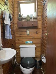 a small bathroom with a toilet and a sink at Miramar Chalé e Suítes in Angra dos Reis