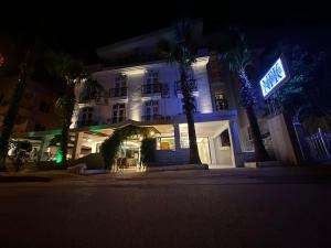 a white building with a lit up sign at night at NFK The House Hotel in Antalya