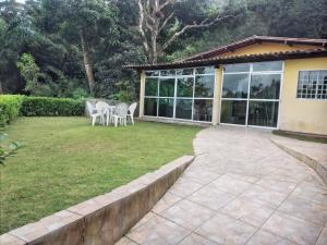 eine Terrasse mit Tisch und Stühlen in einem Hof in der Unterkunft Linda casa em Guaramiranga in Guaramiranga