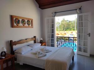Schlafzimmer mit einem Bett und einer Glasschiebetür in der Unterkunft Pousada Portal de Paraty in Paraty