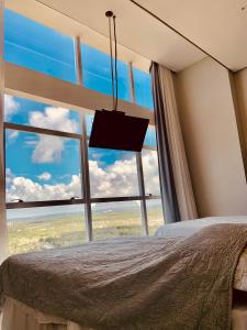 a bedroom with a large window with a view of the ocean at Paiva Flats By Loui in Recife