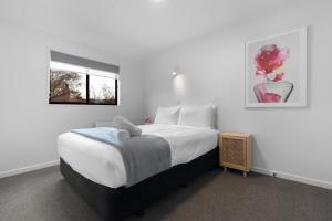 a bedroom with a bed with a teddy bear on it at Location, Location in Queenstown