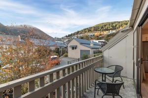 a patio with two chairs and a table on a balcony at Location, Location in Queenstown