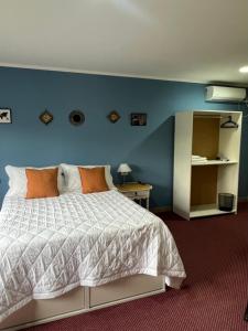 1 dormitorio con cama y pared azul en La Sicilia Chacra en Villa Regina