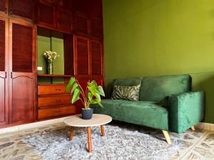 a green couch in a living room with a table at Tranquil Master Suite, Your Private Escape in Medellín