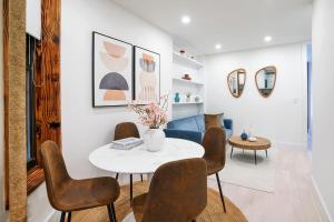 - un salon avec une table et des chaises blanches dans l'établissement 48-3RW Brand New 1BR Prime Hells Kitchen - W D, à New York