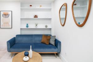 - un canapé bleu dans le salon avec une table dans l'établissement 48-3RW Brand New 1BR Prime Hells Kitchen - W D, à New York