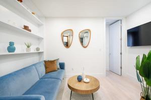 - un salon avec un canapé bleu et une table dans l'établissement 48-3RW Brand New 1BR Prime Hells Kitchen - W D, à New York