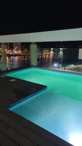 una piscina por la noche con vistas a la ciudad en Temporario Citrino De La Costanera en Posadas