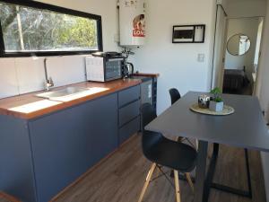 cocina con encimera y mesa con fregadero en Aires de mar en Huerta Grande