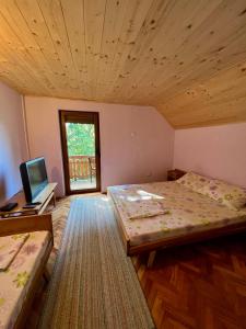 a room with two beds and a television in it at Konaci Nikola Banja Vrujci in Gornja Toplica