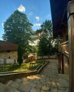 una pasarela de piedra frente a un edificio con árboles en Konaci Nikola Banja Vrujci en Gornja Toplica