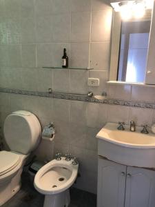 y baño con aseo blanco y lavamanos. en Apartamento amoblado de 2 ambientes completo en Buenos Aires