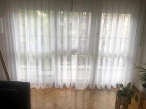 una ventana con cortinas blancas y una maceta en Apartamento amoblado de 2 ambientes completo en Buenos Aires