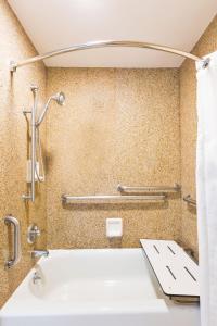 a bathroom with a bath tub and a sink at GreenTree Inn San Diego Mission Bay in San Diego