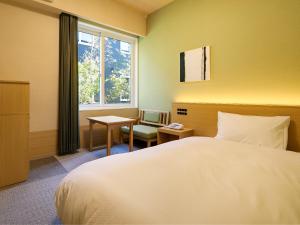 天理市にあるグランヴィリオホテル奈良 和蔵 -ルートインホテルズ-のベッドルーム1室(ベッド1台、椅子、窓付)