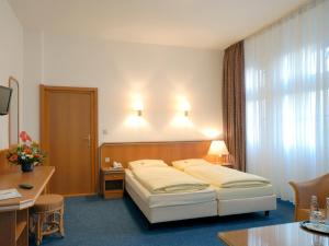 ein Hotelzimmer mit einem Bett und einem Schreibtisch in der Unterkunft Hotel und Rasthof AVUS in Berlin