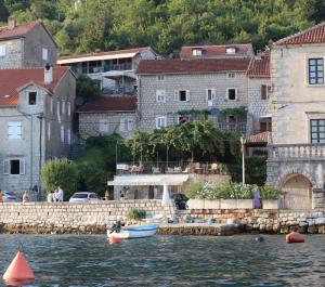 un groupe de bâtiments et une masse d'eau avec des bateaux dans l'établissement Guesthouse Žmukić, à Perast