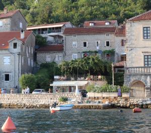 een groep gebouwen en een waterlichaam met boten bij Guesthouse Žmukić in Perast