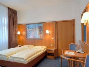 Habitación de hotel con cama grande y escritorio. en Hotel und Rasthof AVUS, en Berlín