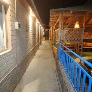 un couloir d'un bâtiment avec une balustrade bleue dans l'établissement Hostal Illauca de Atacama, à San Pedro de Atacama