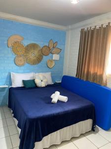 Un dormitorio azul con una cama azul con toallas. en Hospedagem Galés Maragogi, en Maragogi