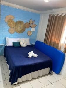 Un dormitorio azul con una cama azul con toallas. en Hospedagem Galés Maragogi, en Maragogi