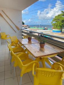 una mesa y sillas en un balcón con vistas al océano en Hospedagem Galés Maragogi, en Maragogi