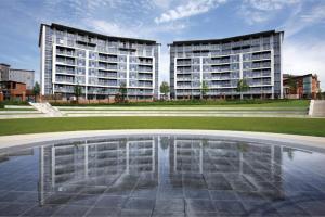 dos edificios altos en una ciudad con una piscina de agua en Beautiful 2 Bed in Central Birmingham: A Hidden Gem!, en Birmingham