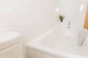 baño con bañera blanca y planta en Beautiful 2 Bed in Central Birmingham: A Hidden Gem!, en Birmingham 10 fotos más