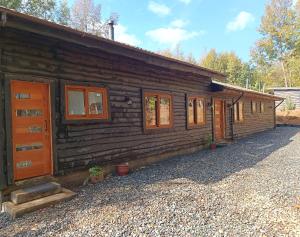 a log cabin with a row of doors and windows at Casa con quincho y piscina privados in Recinto