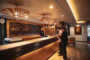 a group of people standing at a bar at Royal Panerai Hotel Chiangmai in Chiang Mai