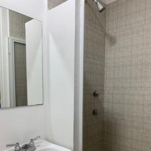 a bathroom with a sink and a mirror and a shower at Container Inn Hotel Aeropuerto in Puerto Vallarta