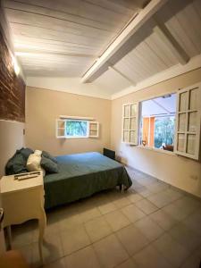 a bedroom with a bed and a desk and a window at Departamento Sofía in Tanti