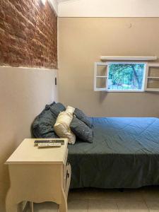 a bedroom with a bed with a table and a window at Departamento Sofía in Tanti