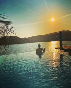 un hombre sentado en una piscina en el agua en El Nido Casa 4 - Paradise on the Bay en Zihuatanejo