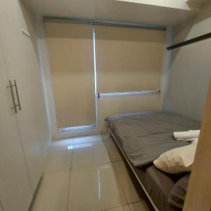 a small room with a bed and a window at Cozy 1 Bedroom in Makati City in Manila