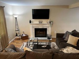 a living room with a couch and a fireplace at Cozy cottage by the lake in Tobyhanna